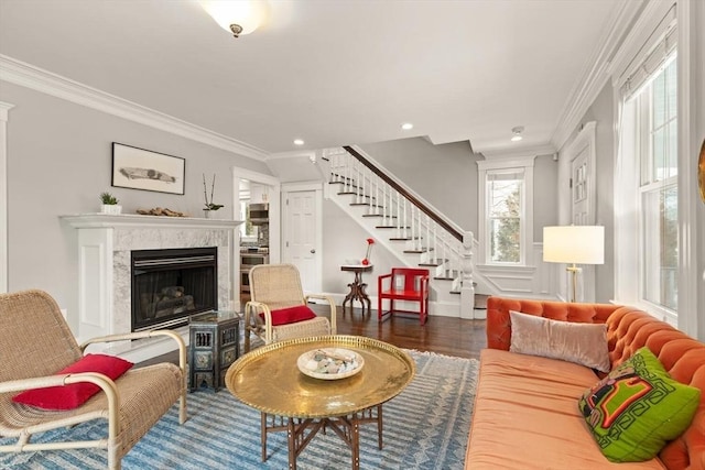 living room with ornamental molding, stairway, dark wood finished floors, and a high end fireplace