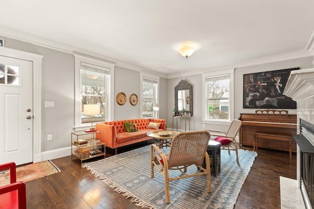 sitting room with dark wood-style floors, crown molding, and baseboards