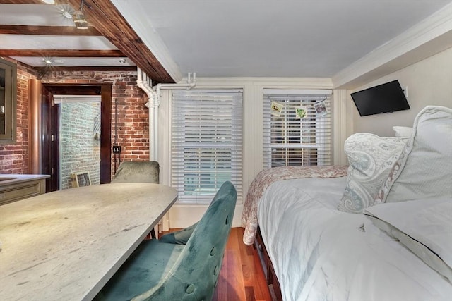 bedroom featuring beam ceiling, dark wood-type flooring, and brick wall