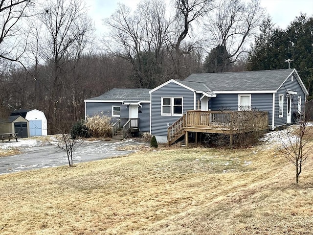 view of front facade featuring a shed, a front lawn, and a deck