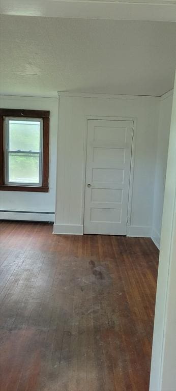 1 Barber Ave, Greenfield, MA 01301 - empty room with dark wood-style floors, baseboards, and a baseboard heating unit