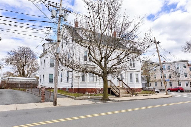 view of front of home featuring a residential view, fence, and a chimney