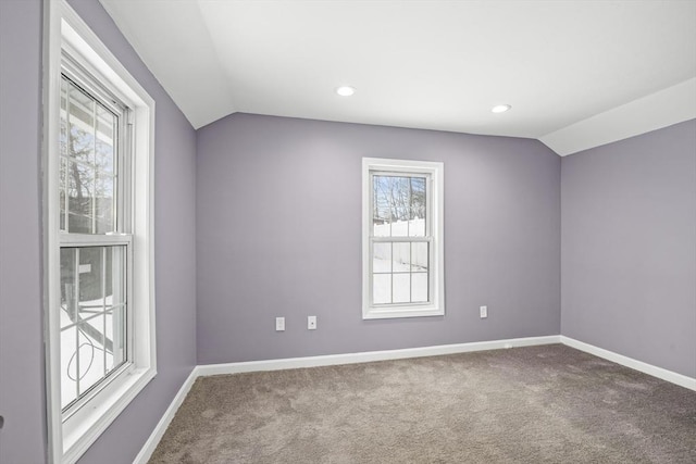 spare room featuring carpet floors and vaulted ceiling