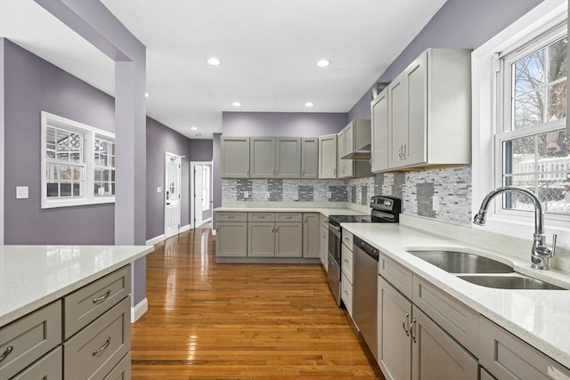 kitchen with hardwood / wood-style flooring, sink, appliances with stainless steel finishes, and gray cabinetry