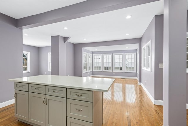 kitchen with light hardwood / wood-style floors, a center island, and gray cabinetry