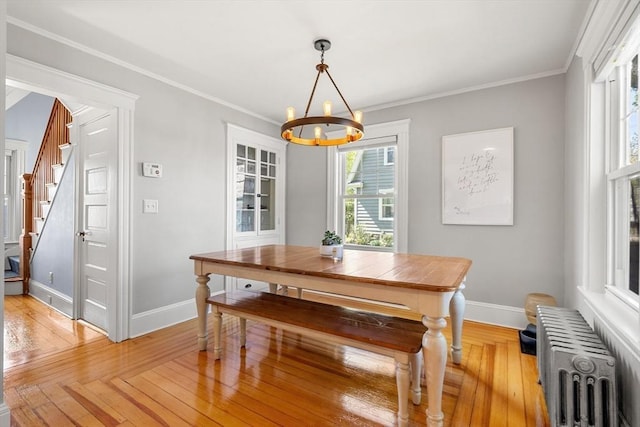 dining area featuring a notable chandelier, stairway, baseboards, and radiator heating unit