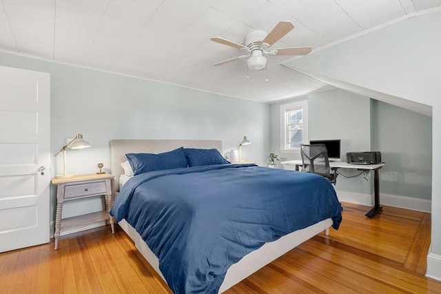bedroom with crown molding, ceiling fan, and wood finished floors