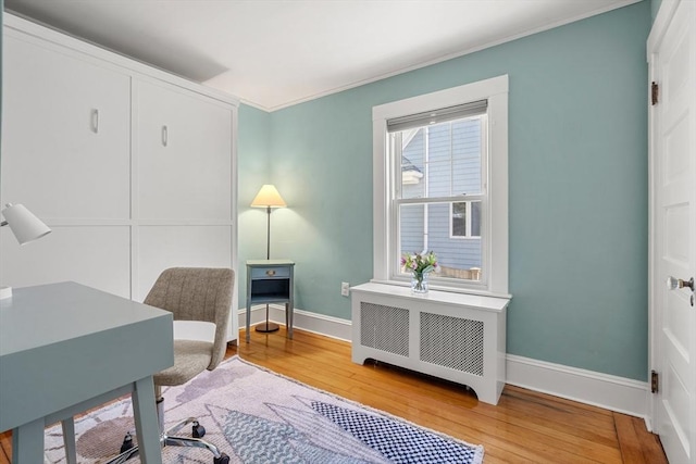 home office with baseboards, radiator, light wood-style floors, and ornamental molding