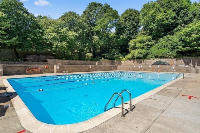 44 Washington St Unit 1208, Brookline, MA 02445 - community pool featuring a patio and view of wooded area