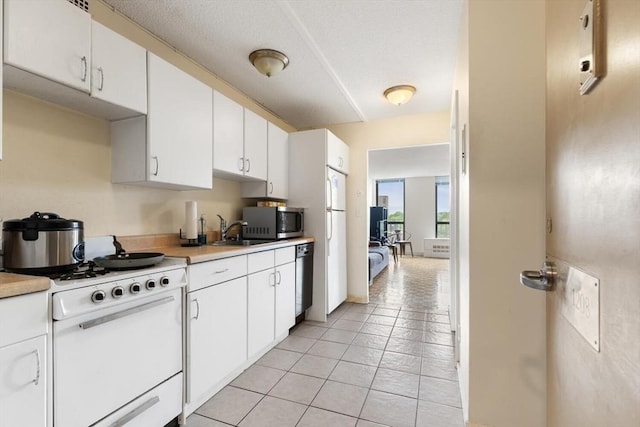 44 Washington St Unit 1208, Brookline, MA 02445 - kitchen featuring stainless steel appliances, light countertops, a sink, and white cabinetry