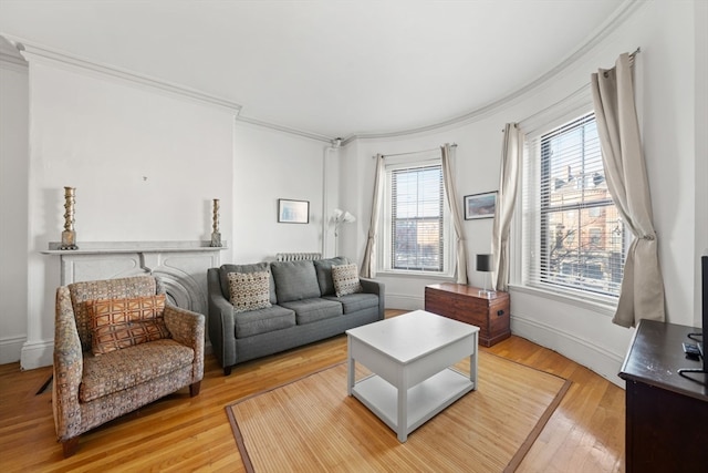 living room featuring ornamental molding, a wealth of natural light, and light hardwood / wood-style flooring