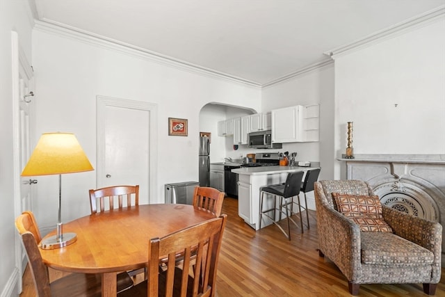 dining space with light hardwood / wood-style floors and crown molding