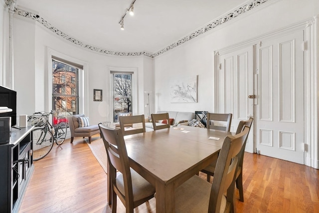 dining room featuring rail lighting and light wood-type flooring