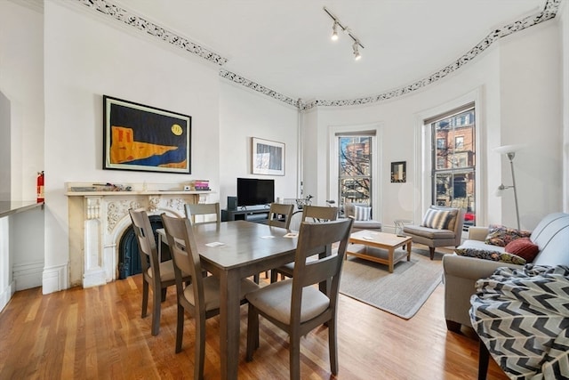 dining area with hardwood / wood-style flooring and track lighting