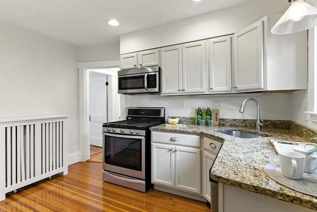 88 Brush Hill Rd, Milton, MA 02186 - kitchen with stainless steel appliances, recessed lighting, light wood-style floors, light stone countertops, and hanging light fixtures