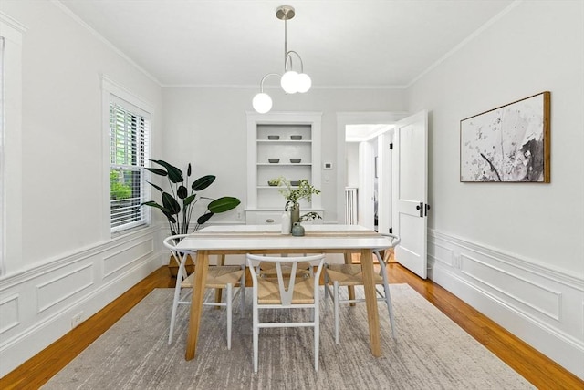 88 Brush Hill Rd, Milton, MA 02186 - dining space with wood finished floors, ornamental molding, wainscoting, a decorative wall, and a chandelier