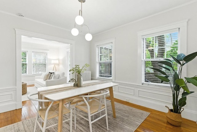 88 Brush Hill Rd, Milton, MA 02186 - dining space featuring ornamental molding, healthy amount of natural light, radiator, light wood-style flooring, and wainscoting