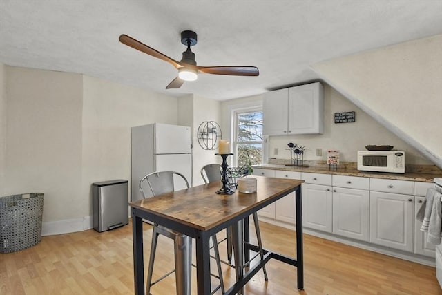 kitchen with white cabinetry, ceiling fan, white appliances, and light wood-type flooring