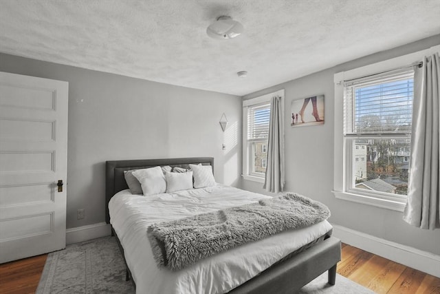 bedroom with dark hardwood / wood-style flooring and a textured ceiling