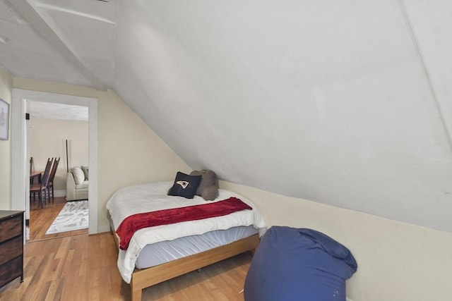 bedroom featuring wood-type flooring and vaulted ceiling