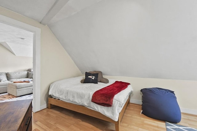 bedroom featuring light hardwood / wood-style floors and lofted ceiling