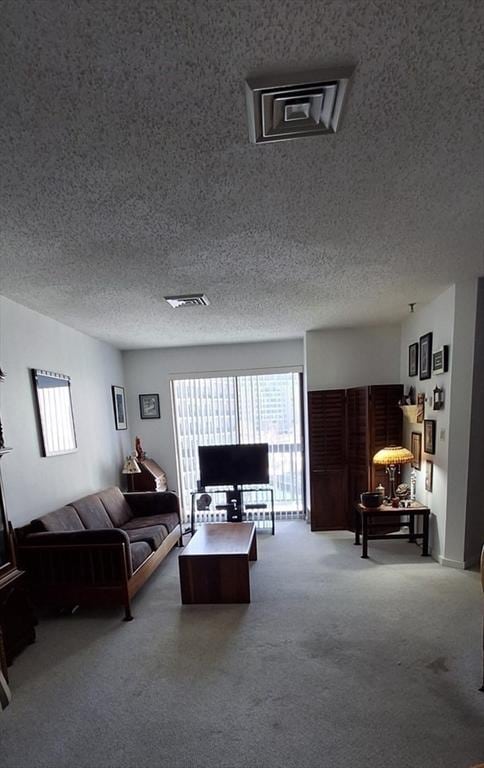 carpeted living area with visible vents and a textured ceiling