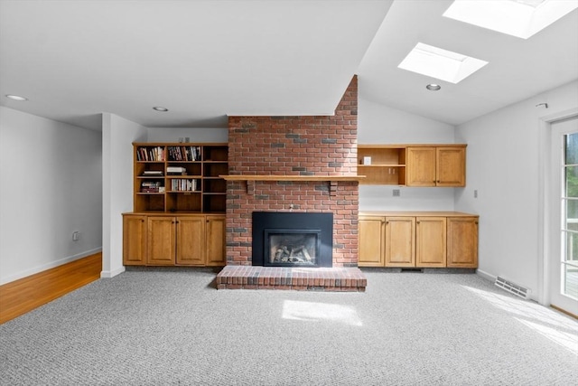 9 William Bradford Rd, Dartmouth, MA 02747 - unfurnished living room with a skylight, light colored carpet, a fireplace, baseboards, and lofted ceiling