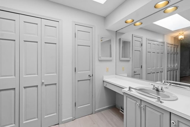9 William Bradford Rd, Dartmouth, MA 02747 - bathroom with a skylight, vanity, a closet, and baseboards