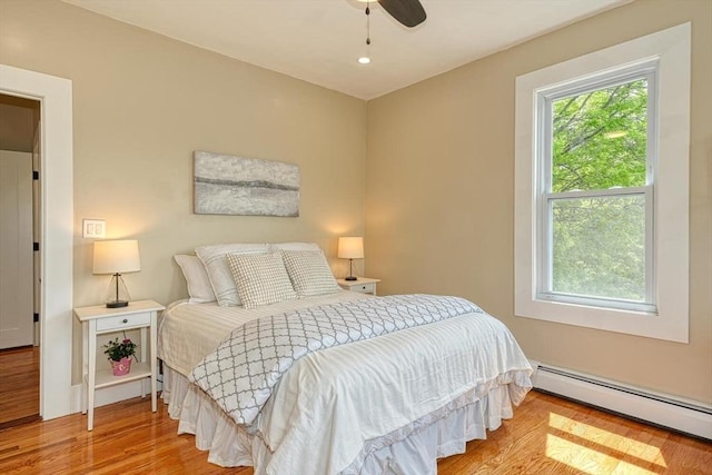 bedroom featuring baseboard heating, wood finished floors, recessed lighting, and ceiling fan