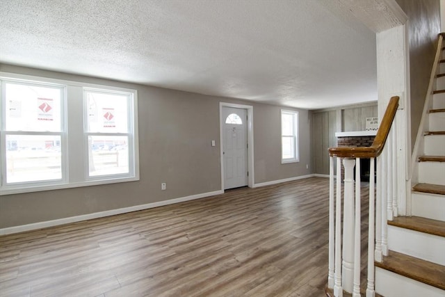 foyer entrance with light hardwood / wood-style flooring and a textured ceiling