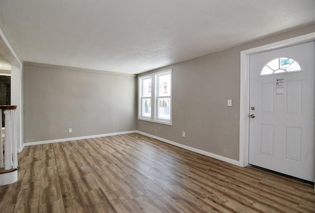 foyer entrance featuring hardwood / wood-style flooring and a textured ceiling