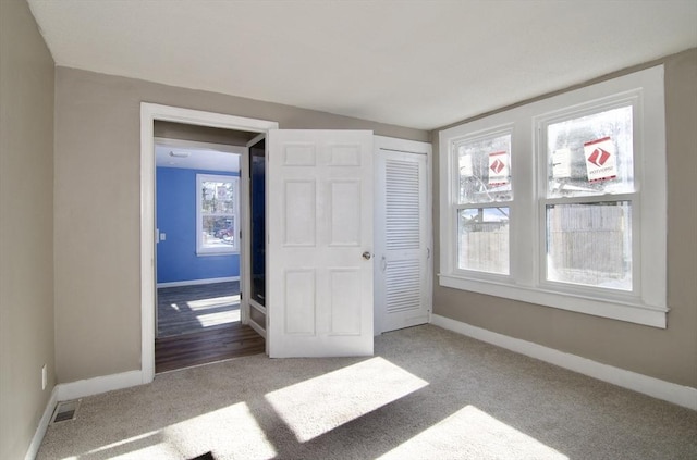 unfurnished bedroom with a closet and light carpet