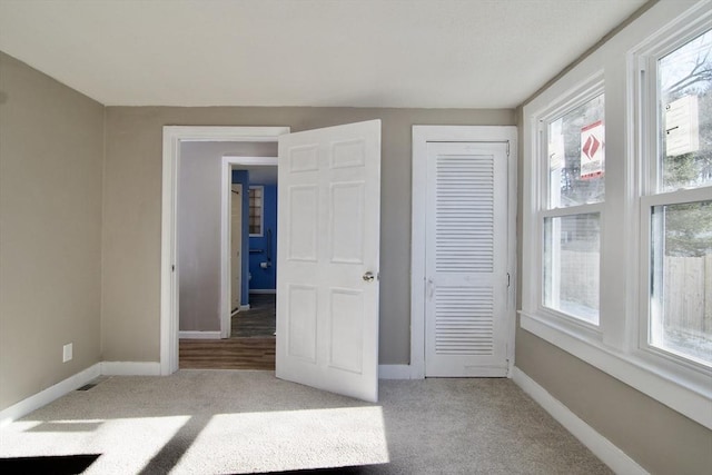 unfurnished bedroom featuring light colored carpet and a closet