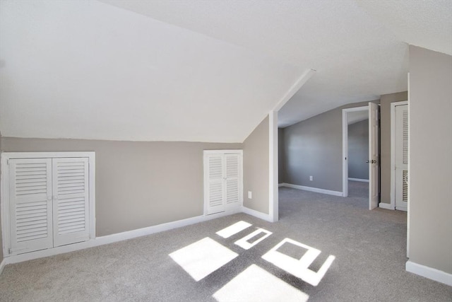 bonus room with light carpet and lofted ceiling