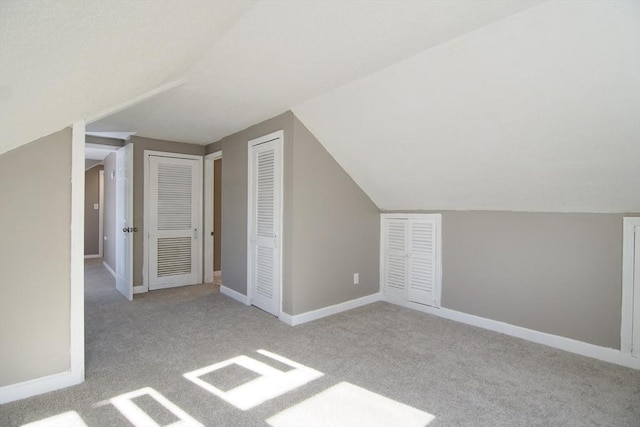 bonus room featuring vaulted ceiling and light carpet