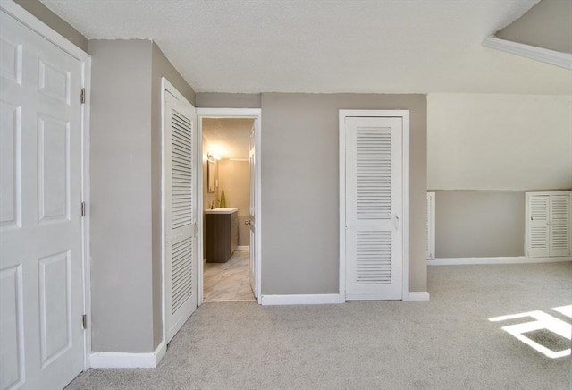 unfurnished bedroom featuring light carpet and ensuite bathroom