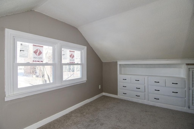 additional living space featuring lofted ceiling and light carpet