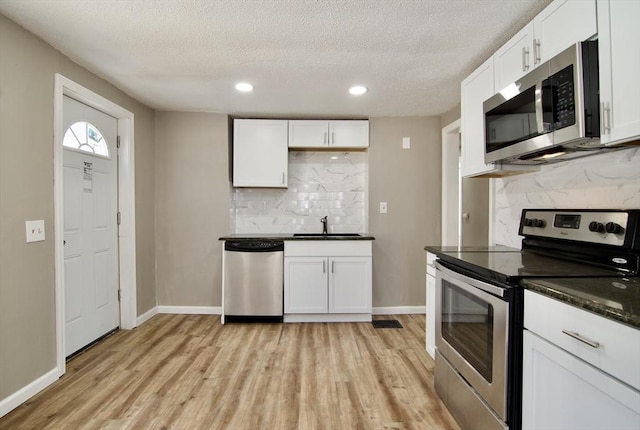 kitchen featuring stainless steel appliances, light hardwood / wood-style floors, sink, and white cabinets