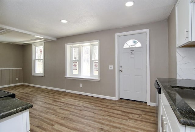 entrance foyer with light hardwood / wood-style floors and a textured ceiling