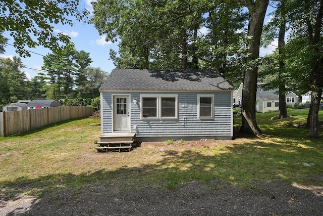 rear view of property featuring a lawn