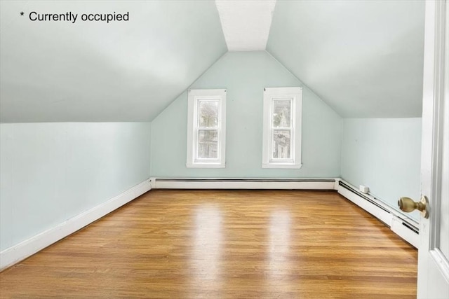 bonus room featuring baseboards, wood finished floors, vaulted ceiling, and a baseboard radiator