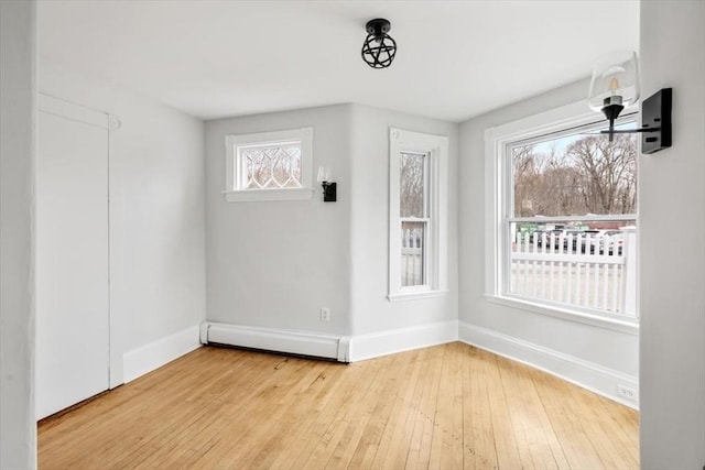 empty room with hardwood / wood-style floors, baseboards, and baseboard heating