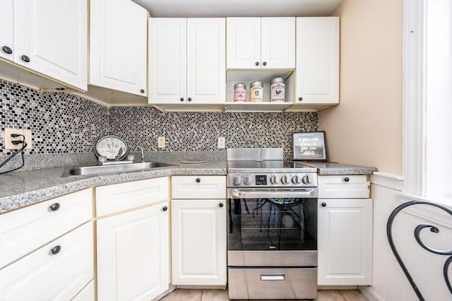 kitchen featuring decorative backsplash, sink, white cabinets, and stainless steel electric range