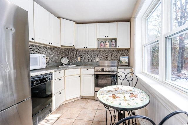 kitchen with backsplash, stainless steel appliances, white cabinets, and light tile patterned flooring