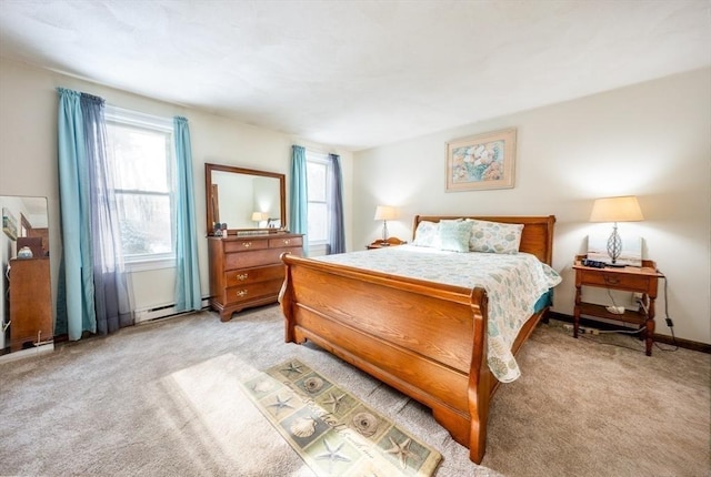 bedroom with a baseboard heating unit and light colored carpet