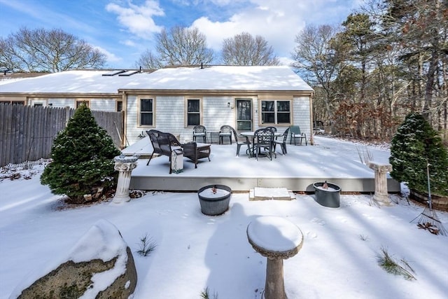 snow covered rear of property featuring an outdoor fire pit