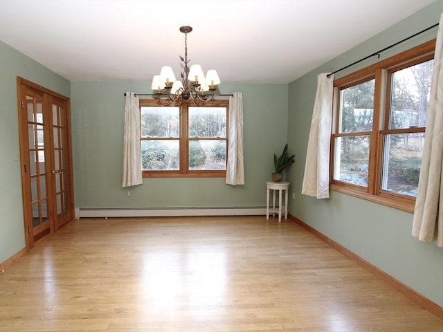 empty room with a chandelier, light wood-type flooring, and baseboard heating