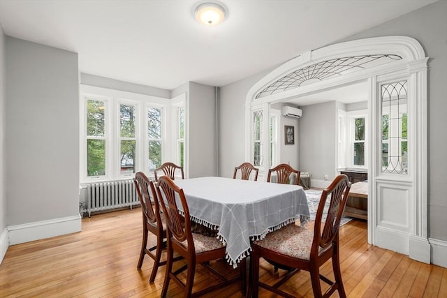 23 Schoolhouse Rd, Templeton, MA 01468 - dining area with radiator heating unit, an AC wall unit, healthy amount of natural light, and light wood finished floors