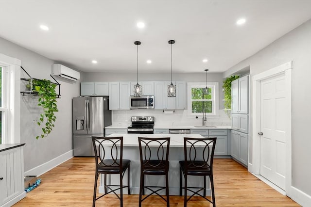 23 Schoolhouse Rd, Templeton, MA 01468 - kitchen with appliances with stainless steel finishes, a wall mounted AC, backsplash, a breakfast bar area, and recessed lighting