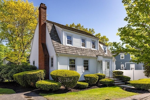 view of front of house featuring a chimney and fence